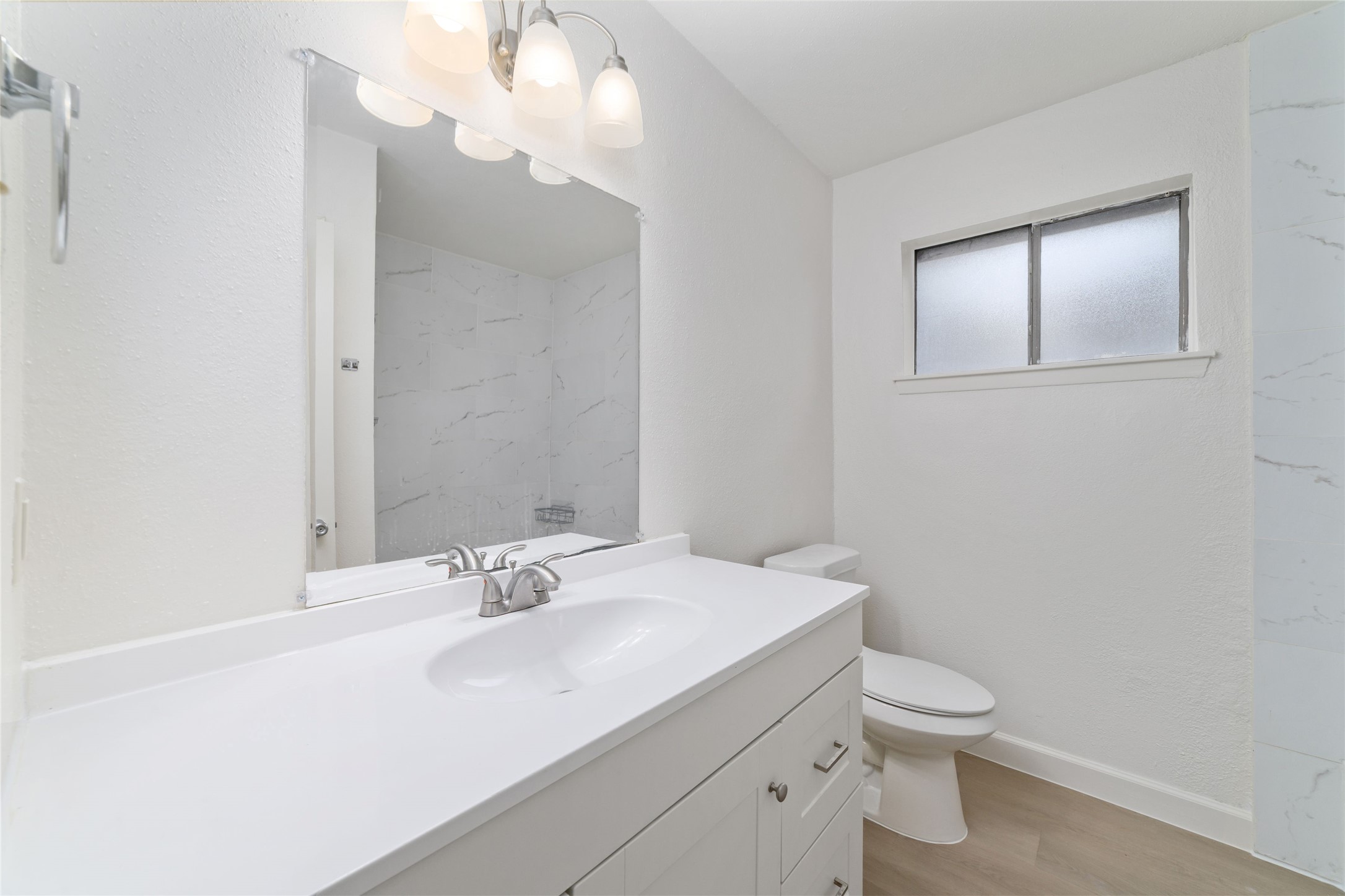 5023 Monteith Drive Spring, TX 77373 - Photo 17 of 20 Clean and updated bathroom with a wide mirror and ample lighting, enhanced by a nearby window that keeps the space bright and open.