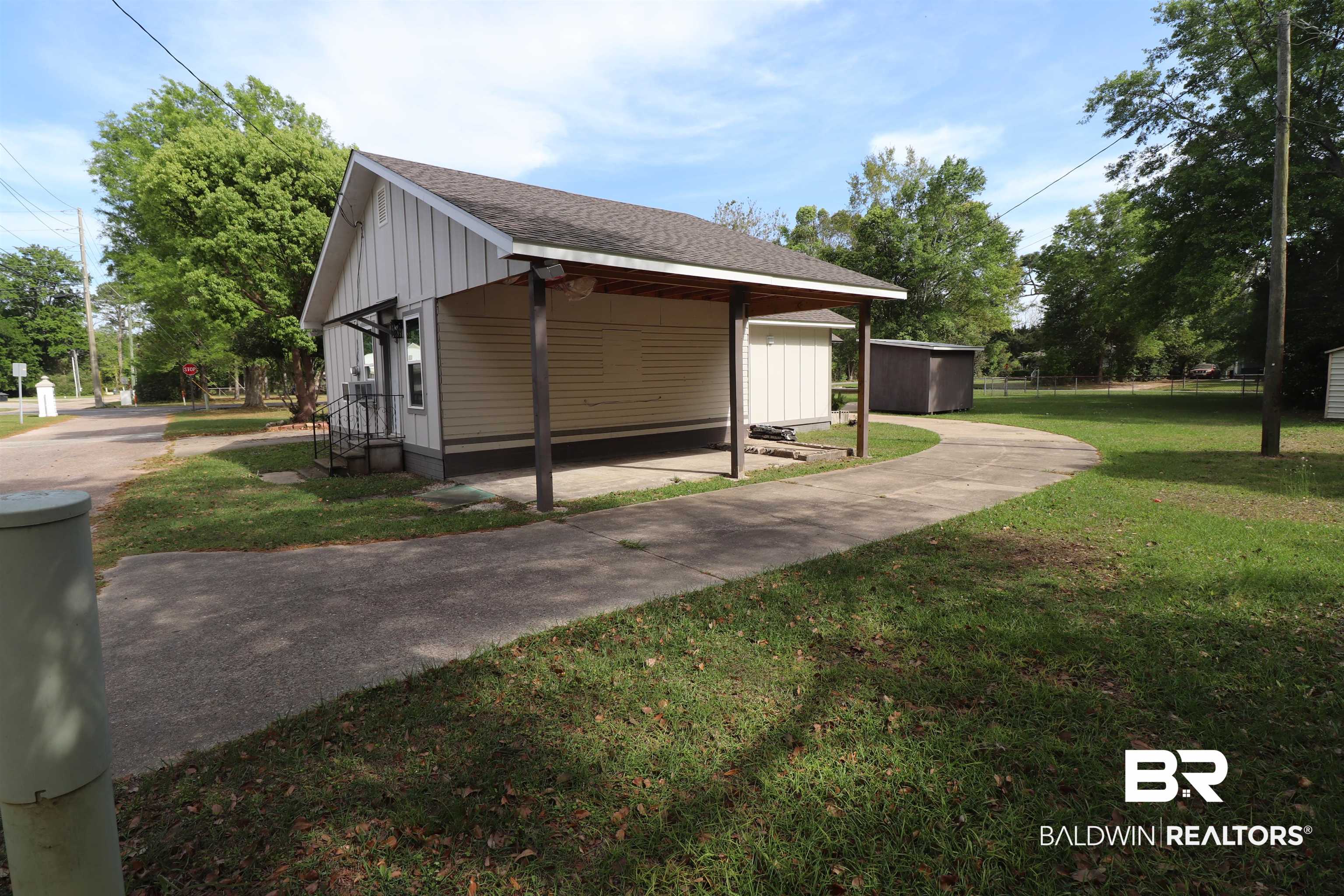 112 South Juniper Street Foley, AL 36535 - Photo 6 of 64 View of side of property with a yard, board and batten siding, a shingled roof, and an outbuilding