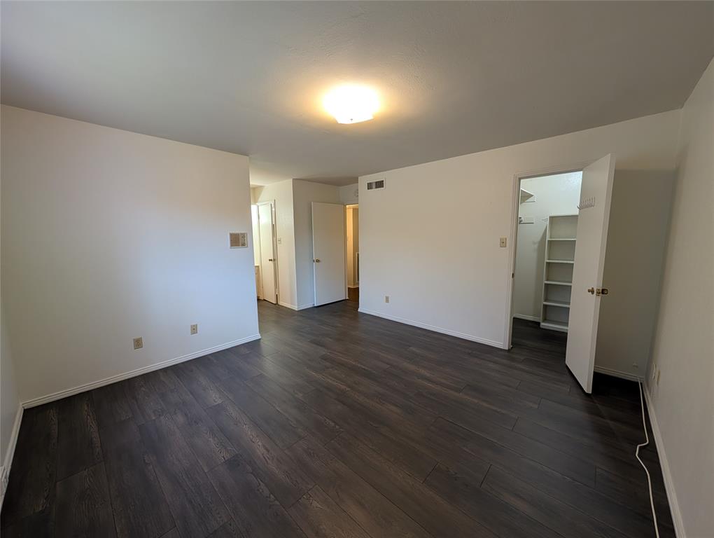 4715 Skillman Street, Unit A Dallas, TX 75206 - Photo 20 of 28 Spacious interior featuring dark wood-finish flooring, white walls, and a ceiling-mounted light fixture