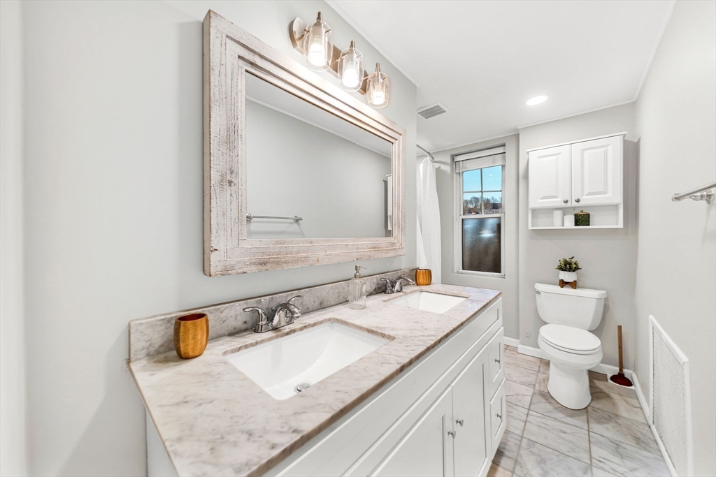 50 Lancaster Terrace, Unit 4 Brookline, MA 02446 - Photo 13 of 20 a bathroom with a granite countertop sink mirror vanity and toilet
