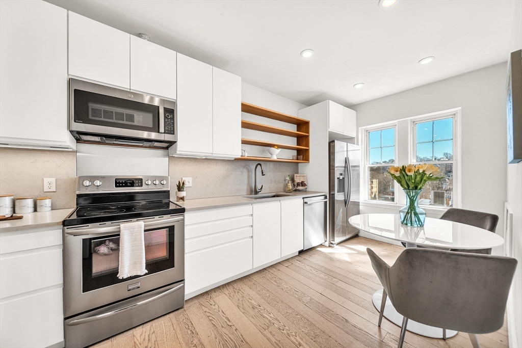 50 Lancaster Terrace, Unit 4 Brookline, MA 02446 - Photo 6 of 20 a kitchen with stainless steel appliances a stove a sink cabinets and a wooden floor