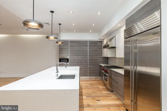 a kitchen with stainless steel appliances a refrigerator and a sink