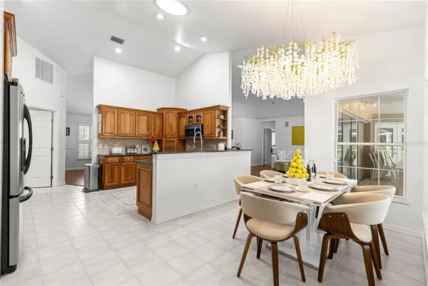 a dining room with kitchen island dining table and stainless steel appliances
