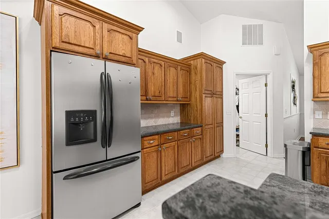 a kitchen with stainless steel appliances granite countertop a refrigerator and a sink