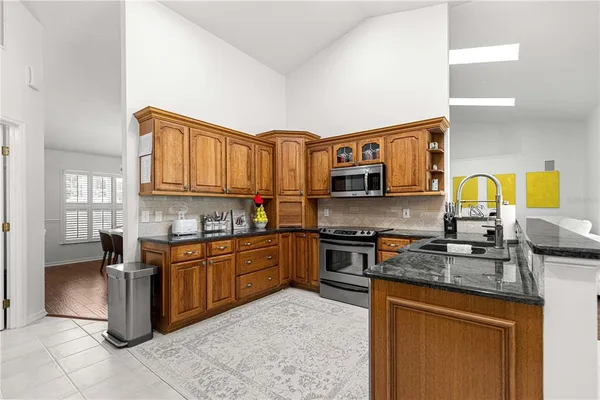 a kitchen with stainless steel appliances granite countertop a stove sink and cabinets