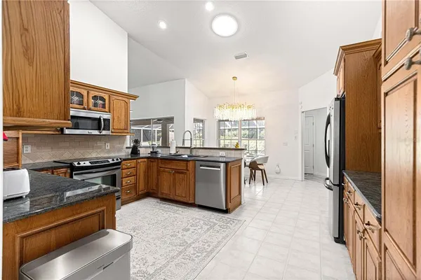 a kitchen with stainless steel appliances granite countertop a stove refrigerator sink and cabinets