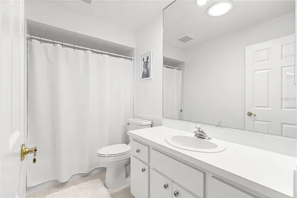a bathroom with a granite countertop sink toilet and a mirror