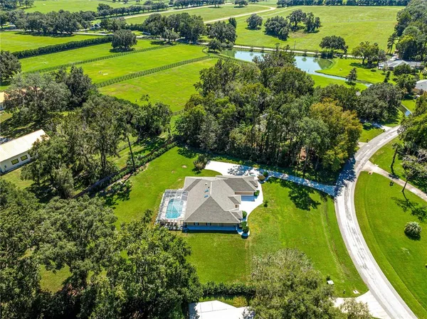 an aerial view of a house with a yard swimming pool outdoor seating and yard