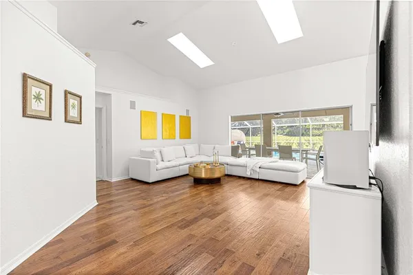 a living room with furniture and a wooden floor