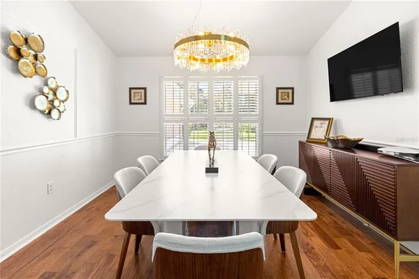 a view of a dining room with furniture a chandelier and wooden floor