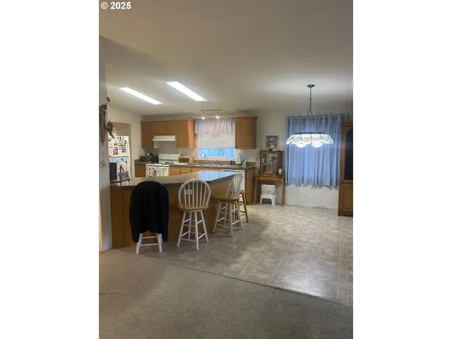 a kitchen with kitchen island granite countertop a sink and a refrigerator