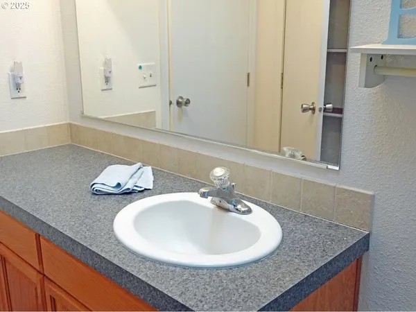 a bathroom with a granite countertop sink and a mirror
