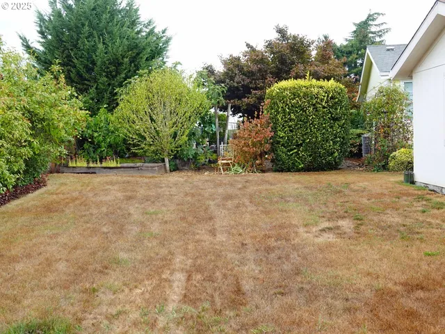 a view of a field with trees in front of the house