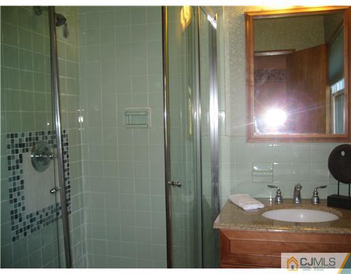 3 Fielding Place Edison, NJ 08820 - Photo 17 of 25 a bathroom with a granite countertop sink a mirror and shower
