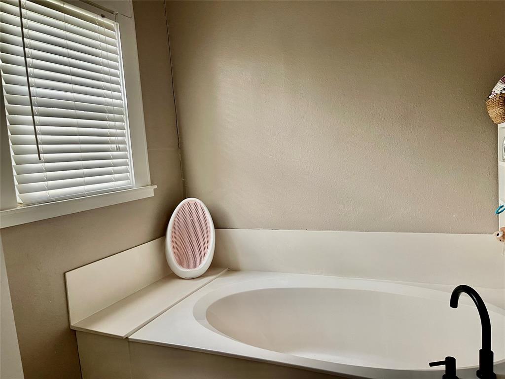 1023 North Spring Street Grand Saline, TX 75140 - Photo 12 of 39 a bathroom with a sink and a bathtub
