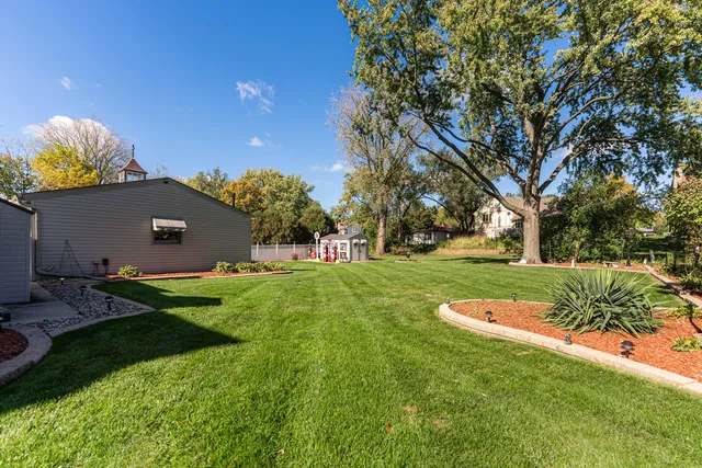 a view of a house with a big yard and a large tree