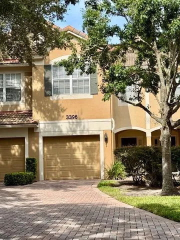 a front view of a house with a yard and potted plants