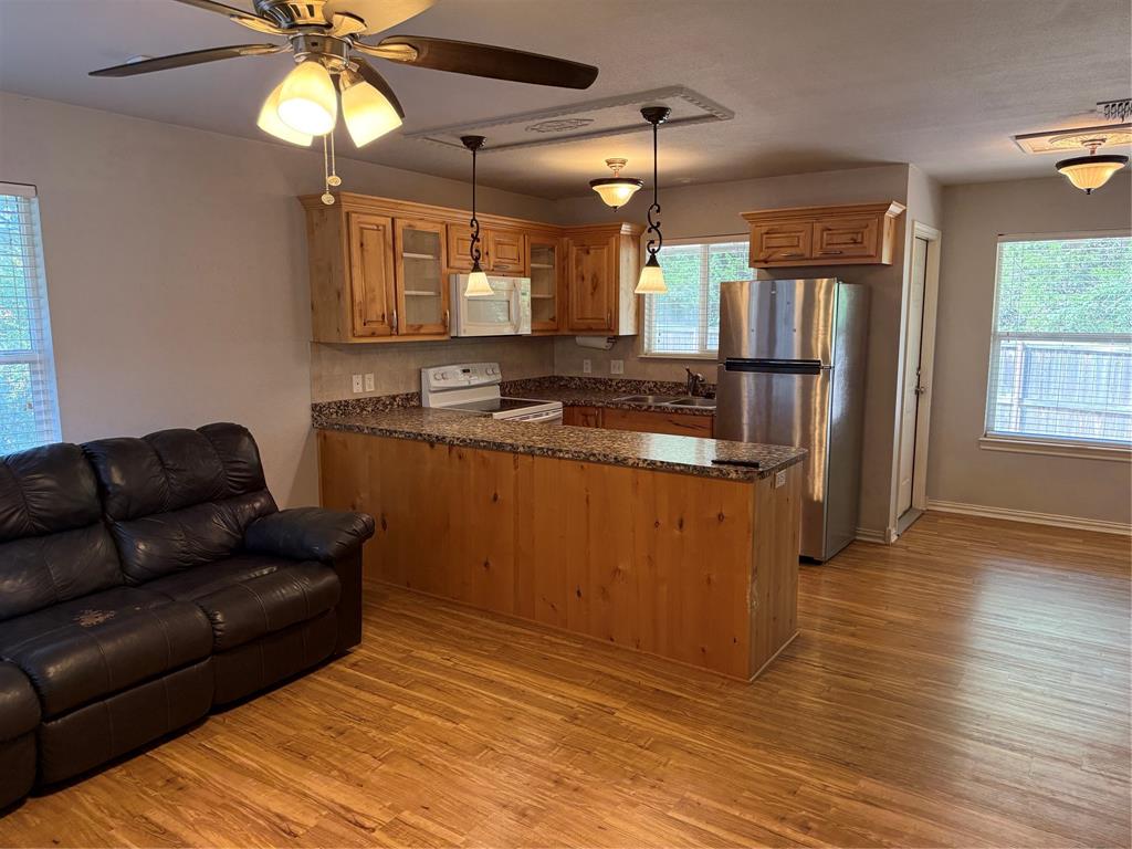 474 Needham Road Pottsboro, TX 75076 - Photo 28 of 40 a kitchen with stainless steel appliances granite countertop a sink and a wooden cabinets