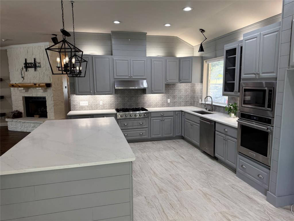 474 Needham Road Pottsboro, TX 75076 - Photo 9 of 40 a kitchen with a sink stainless steel appliances and cabinets