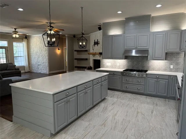 a kitchen with stainless steel appliances a sink a stove a refrigerator and window