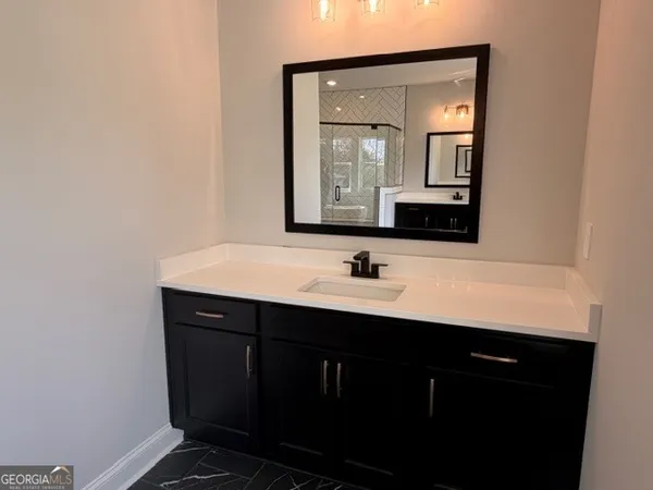 a bathroom with a double vanity sink a toilet a mirror and shower