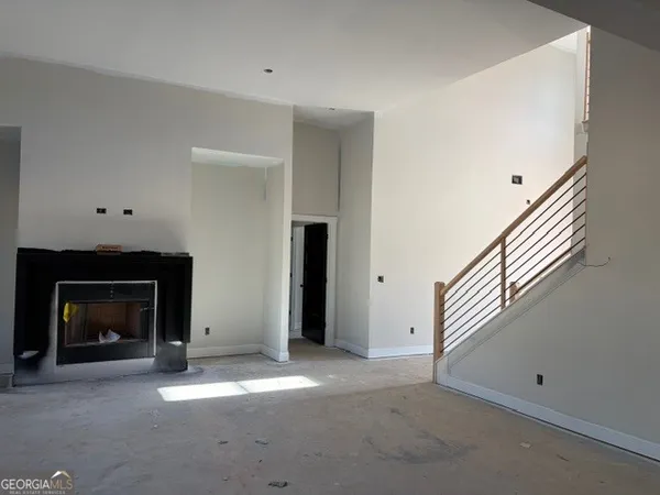 a view of an empty room with fireplace and a window