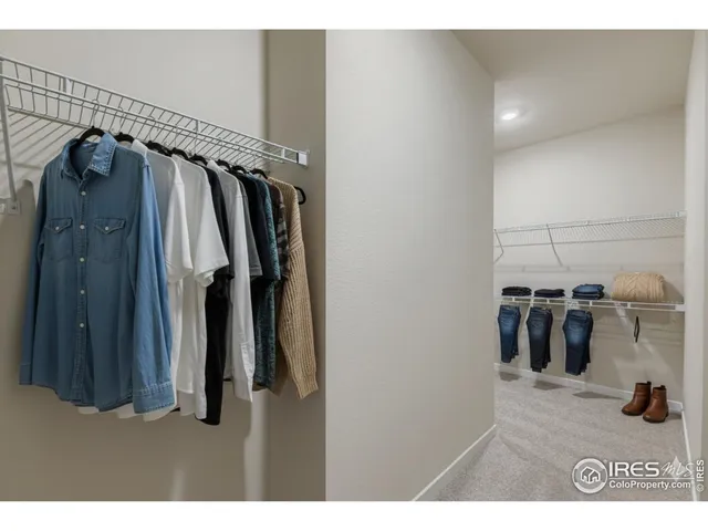 a view of walk in closet with clothes and shoes