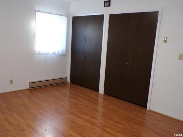 an empty room with wooden floor and closet