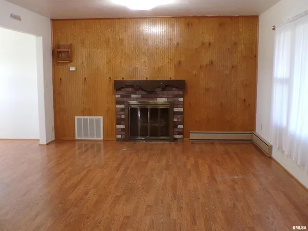 a view of empty room with a fireplace and wooden floor