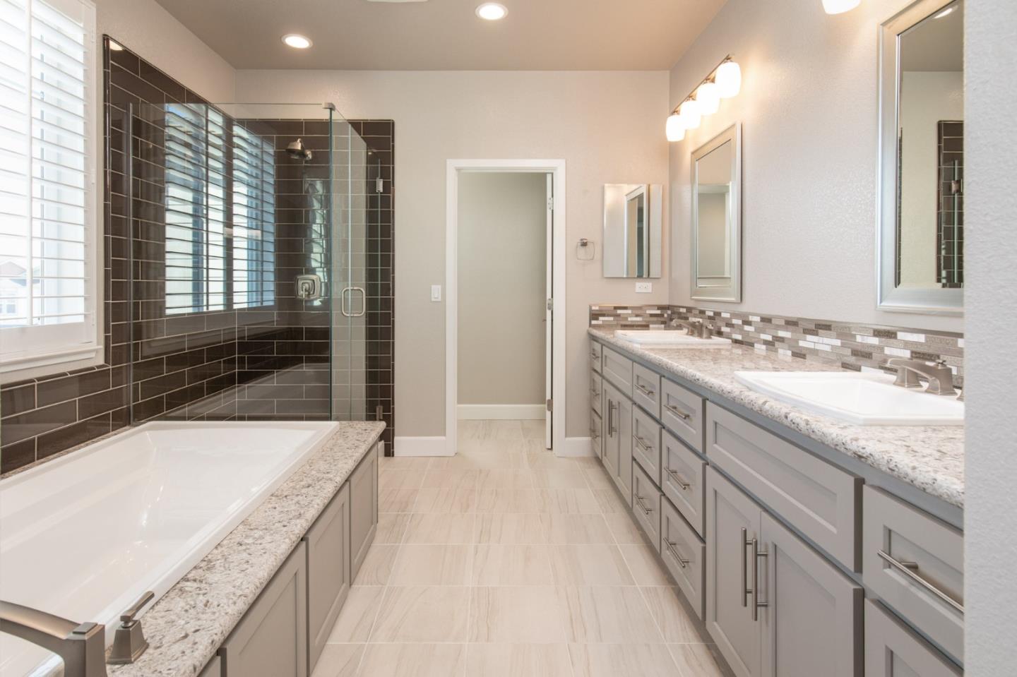 275 10th Street Marina, CA 93933 - Photo 14 of 25 a spacious bathroom with a granite countertop sink a mirror and a bathtub