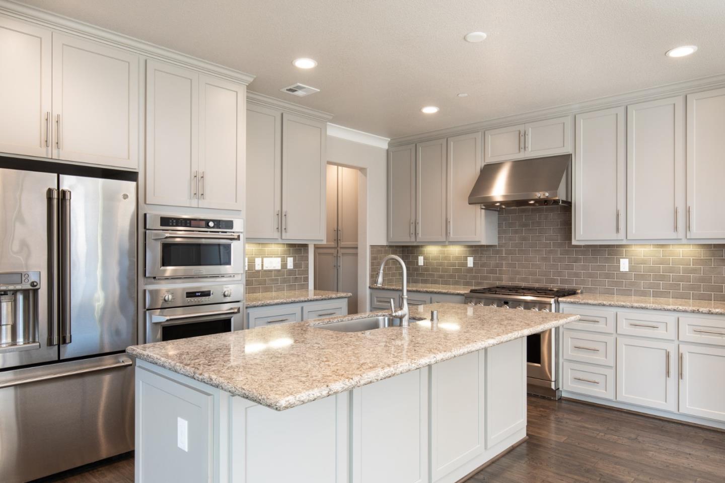 275 10th Street Marina, CA 93933 - Photo 5 of 25 a kitchen with stainless steel appliances granite countertop a sink a stove a refrigerator and cabinets