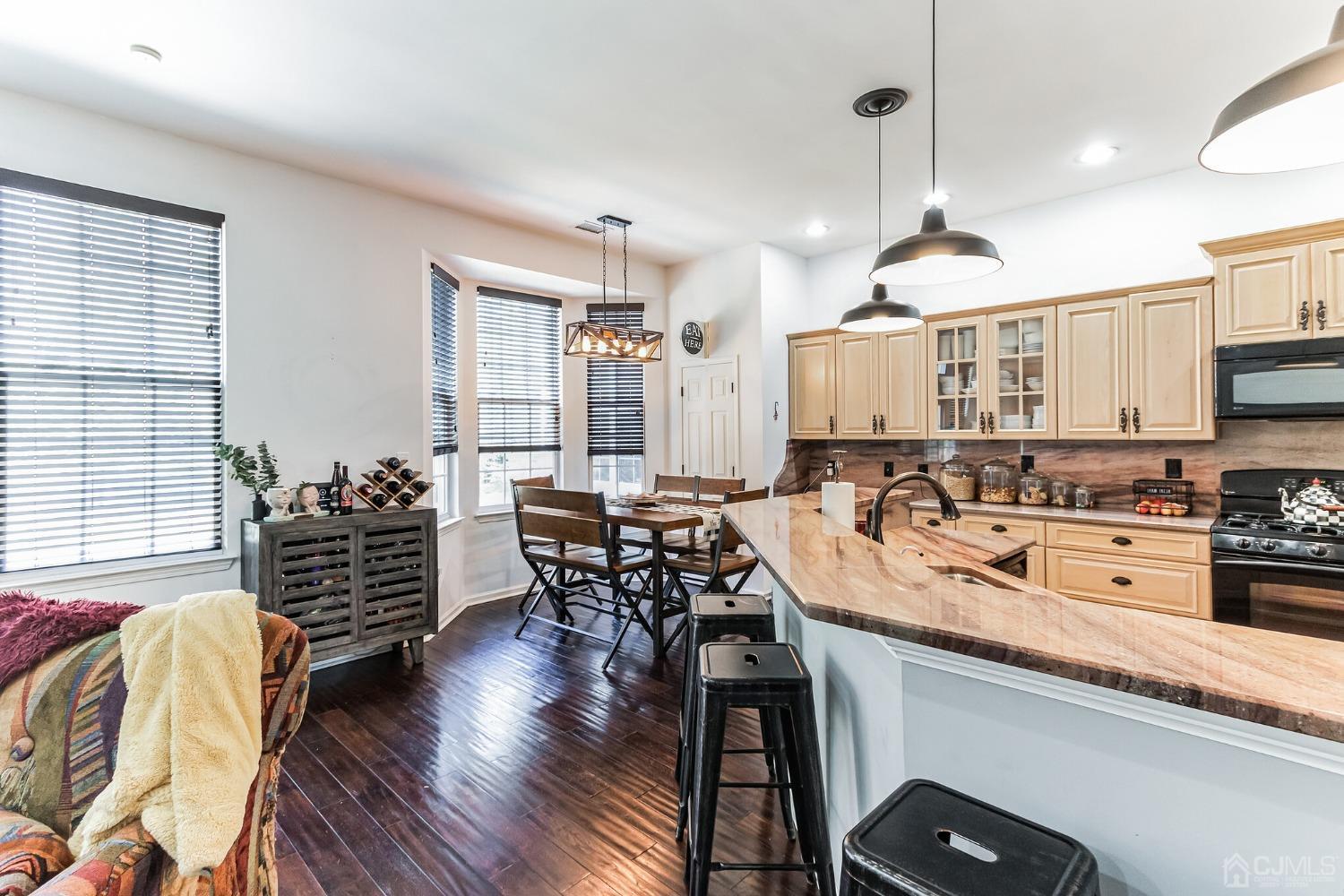 22 Park Ridge Way Jackson, NJ 08527 - Photo 11 of 38 a kitchen with stainless steel appliances a table chairs stove and wooden floor