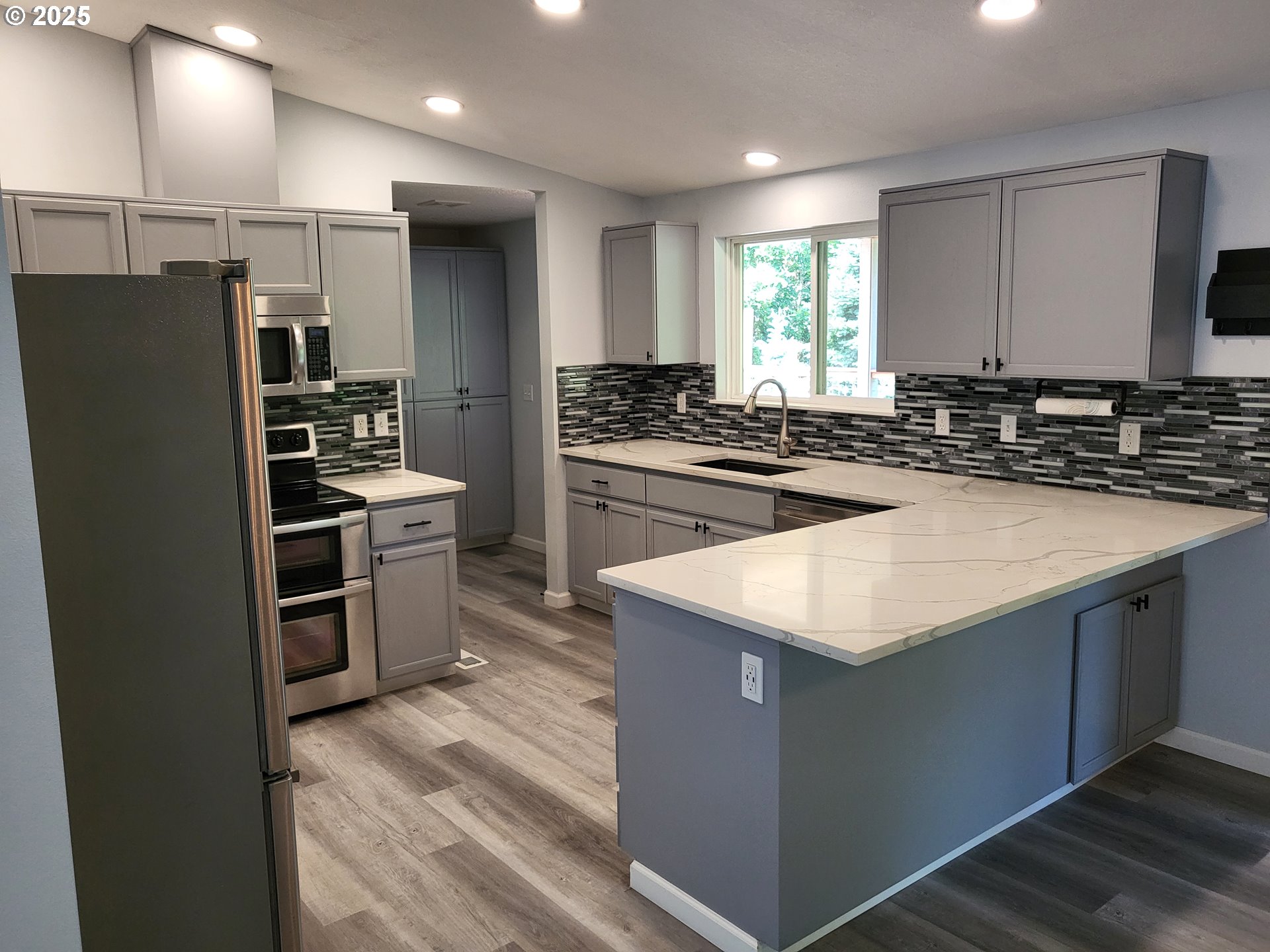 32141 Southeast Mally Road Gresham, OR 97080 - Photo 7 of 36 a kitchen with kitchen island a counter top space a sink stainless steel appliances and cabinets