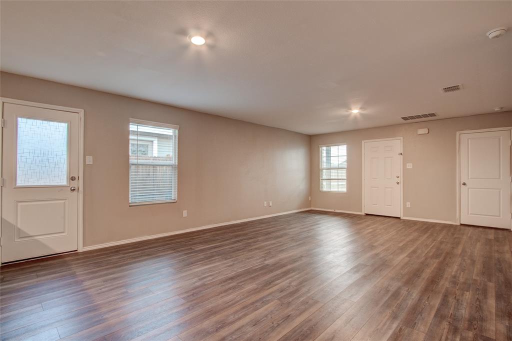 5817 Grindstone Drive Forney, TX 75126 - Photo 5 of 18 an empty room with wooden floor and windows