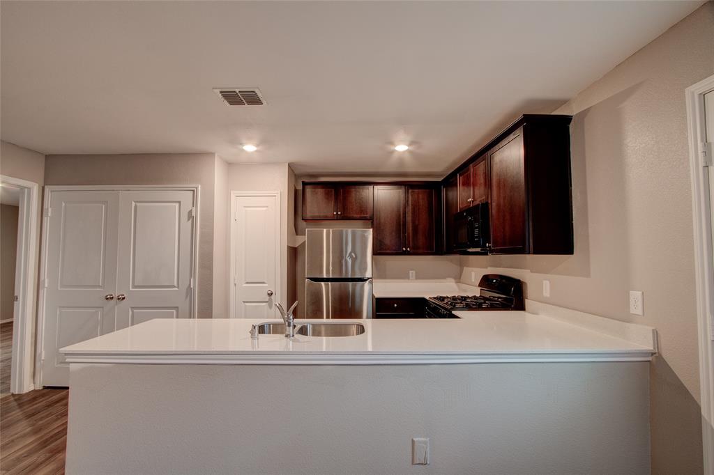 5817 Grindstone Drive Forney, TX 75126 - Photo 7 of 18 a kitchen with kitchen island a sink appliances and cabinets