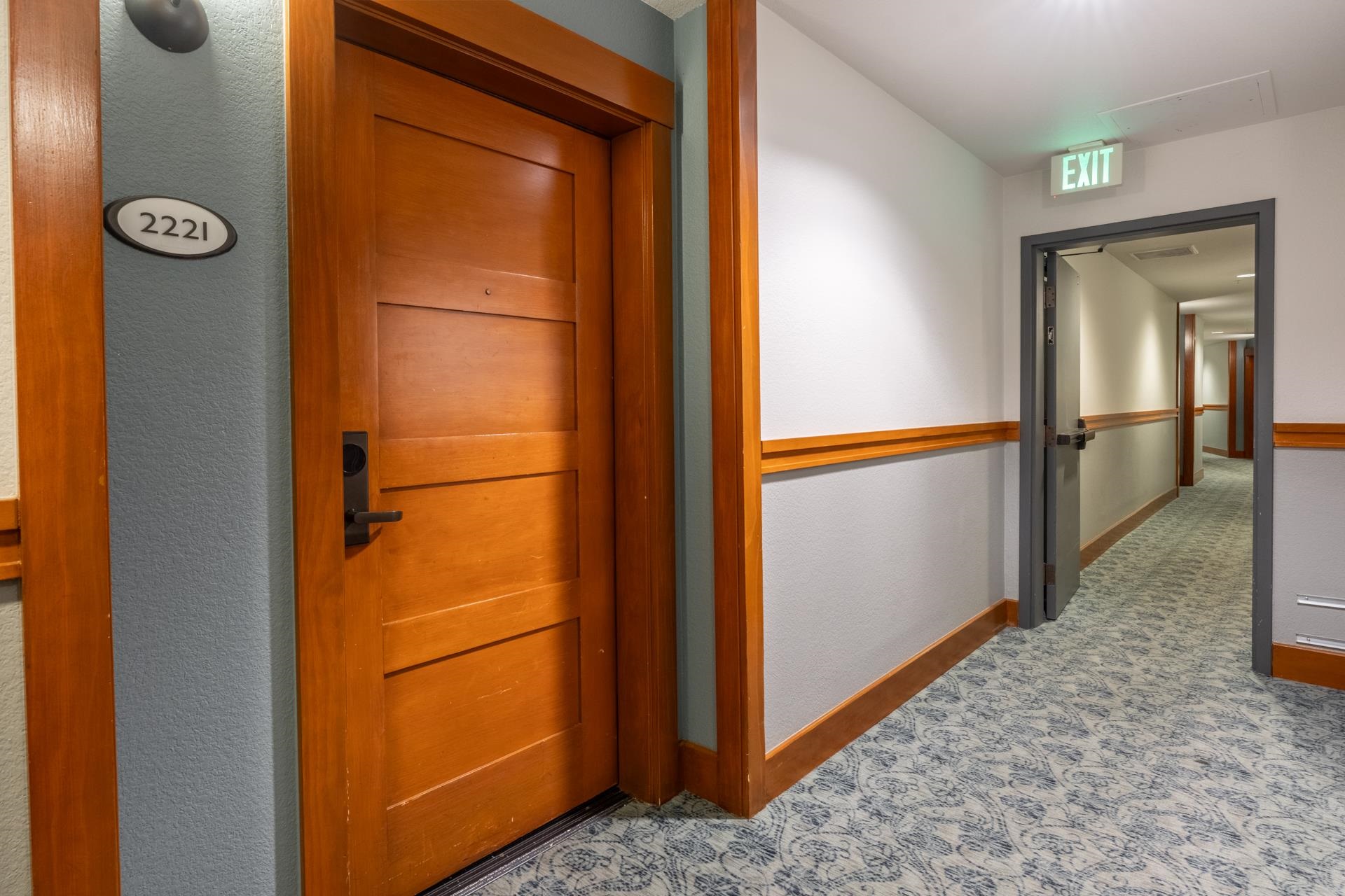 6201 Minaret Road, Unit 2221 Mammoth Lakes, CA 93546 - Photo 2 of 32 Hardwood door with dark hardware, set within a light blue wall with contrasting wood trim