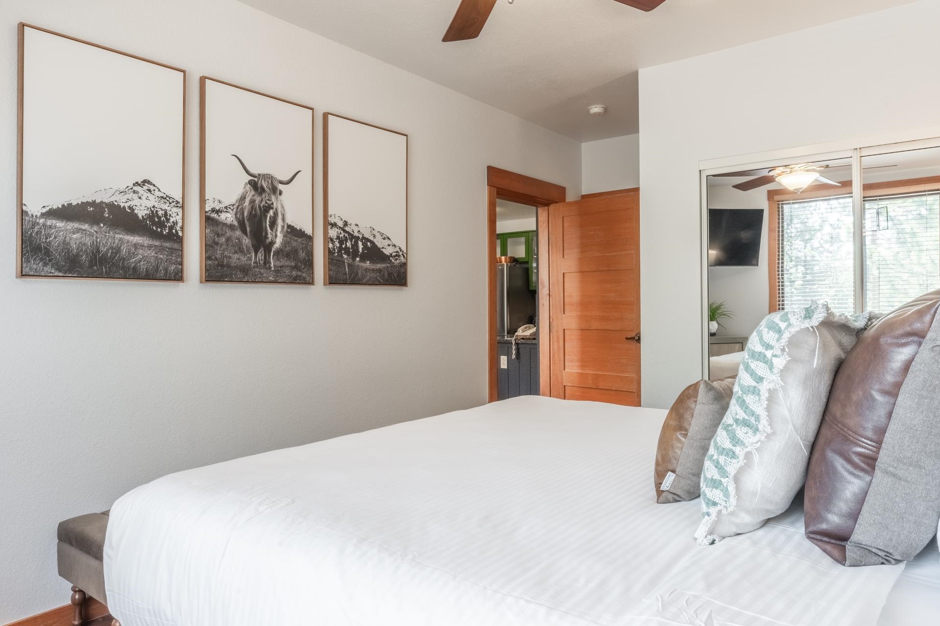 6201 Minaret Road, Unit 2221 Mammoth Lakes, CA 93546 - Photo 30 of 32 Bedroom featuring white walls, a wood-finish ceiling fan, and a wood-panel door