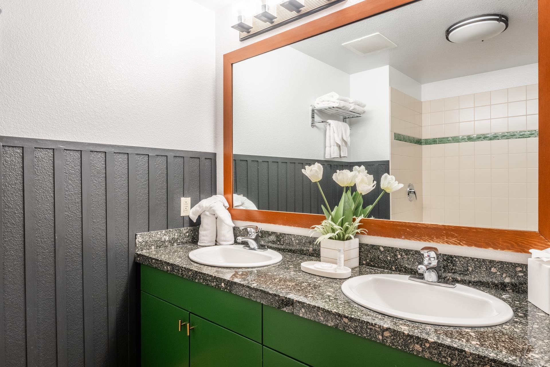 6201 Minaret Road, Unit 2221 Mammoth Lakes, CA 93546 - Photo 31 of 32 Bathroom featuring a double vanity with granite-style countertops, under-mounted sinks, and green cabinetry with brass-finish hardware