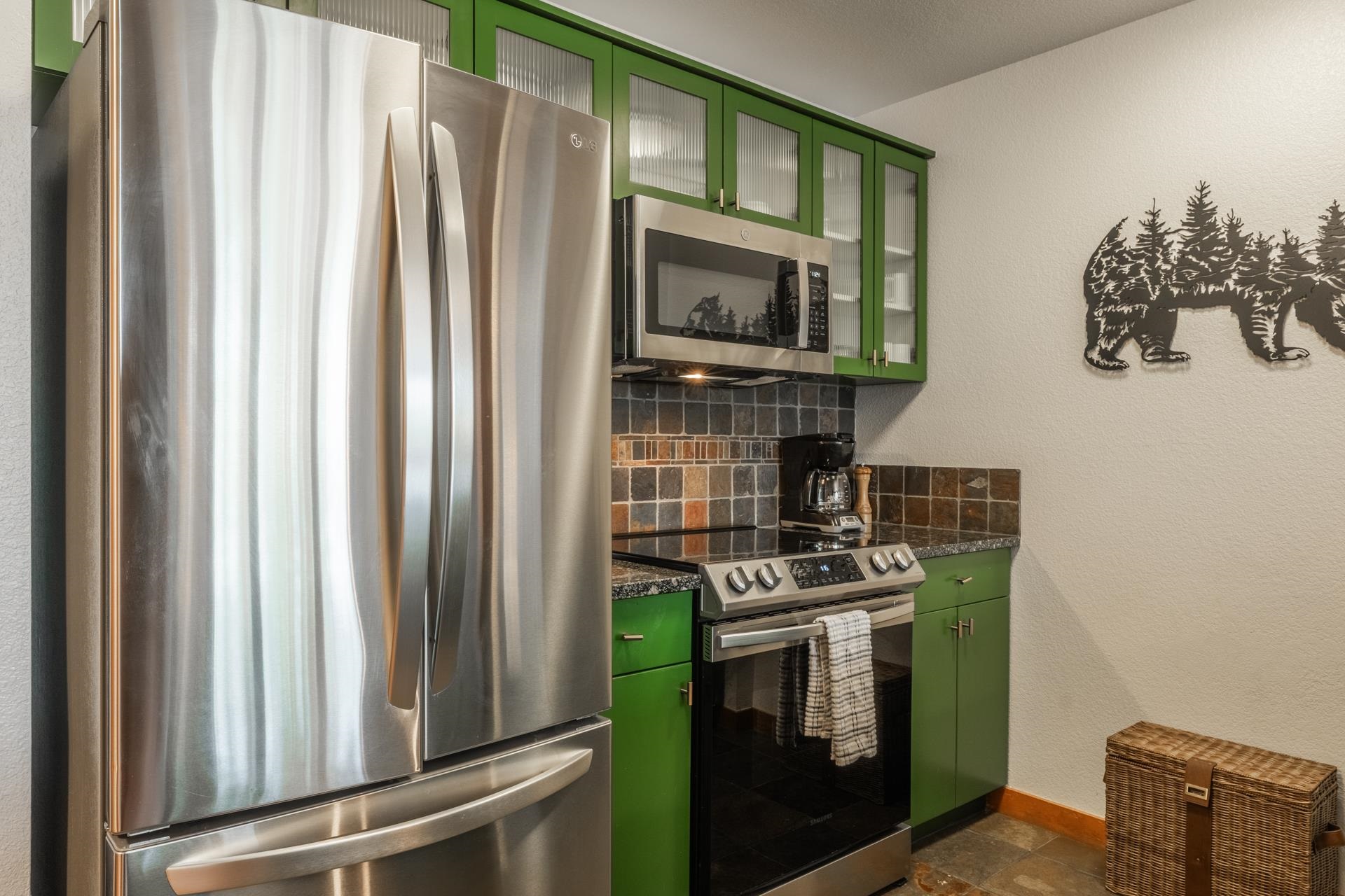 6201 Minaret Road, Unit 2221 Mammoth Lakes, CA 93546 - Photo 8 of 32 Kitchen featuring stainless steel appliances, vibrant green cabinetry, granite-style countertops, and a tiled backsplash