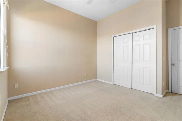 an empty room with windows & cabinet