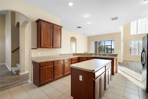 a view of kitchen with stainless steel appliances granite countertop a refrigerator a stove and a sink