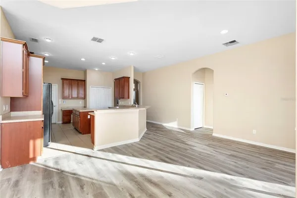 a kitchen with stainless steel appliances granite countertop a stove top oven a refrigerator a sink and dishwasher with wooden floor