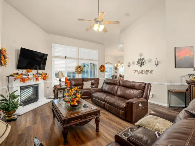 a living room with furniture a flat screen tv and kitchen view