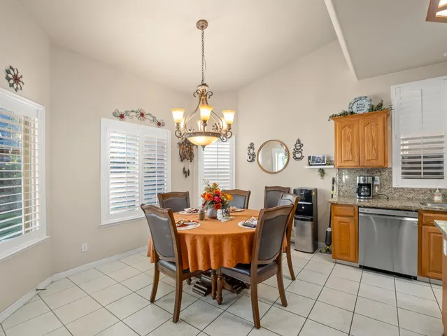 a dining room filled chandelier and kitchen view