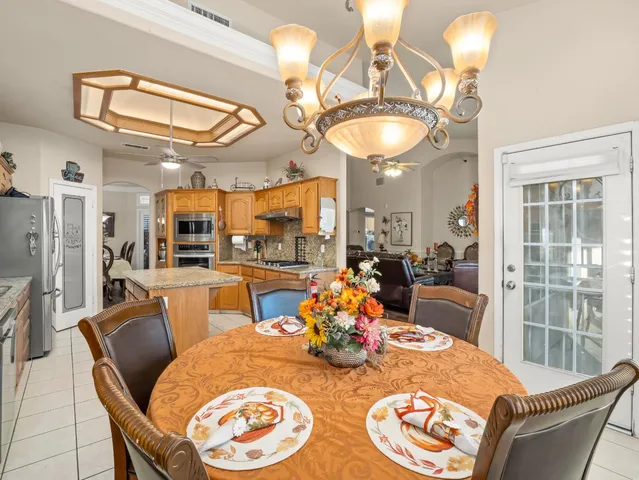 a dining room with furniture a kitchen view and a chandelier