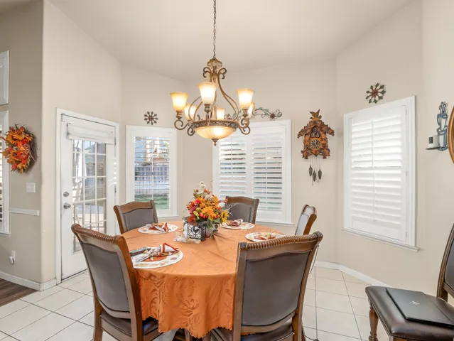 a dining room with furniture a chandelier and window