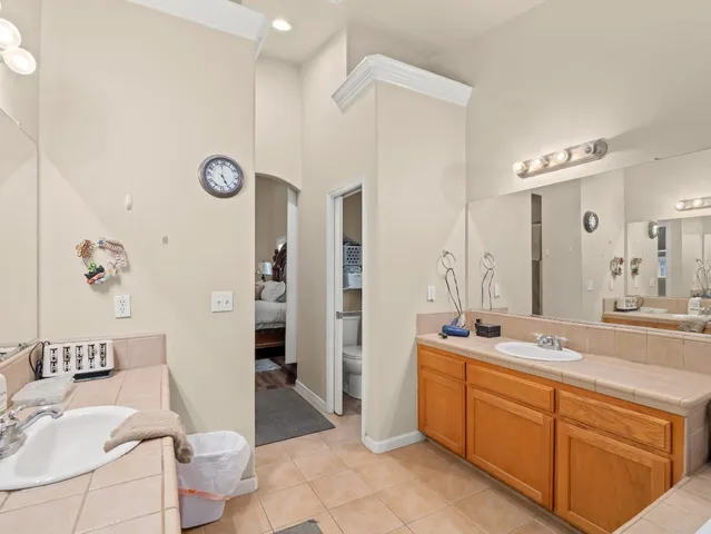 a spacious bathroom with a double vanity sink a mirror and a shower