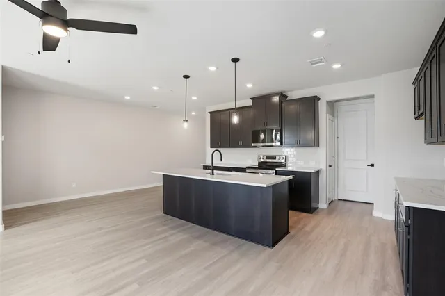 a kitchen with stainless steel appliances granite countertop a sink a oven and wooden cabinets