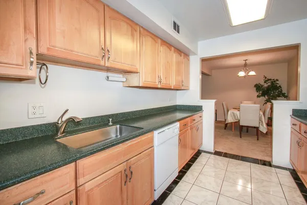 a kitchen with granite countertop a sink and a white cabinets