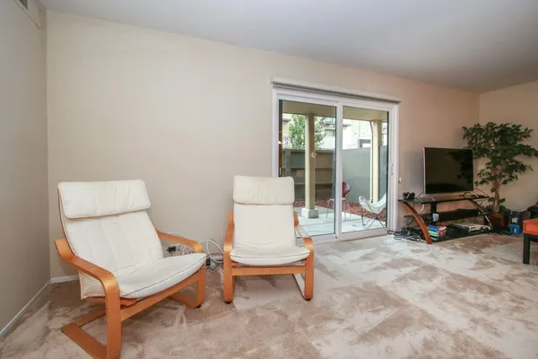a living room with furniture a flat screen tv and a large window